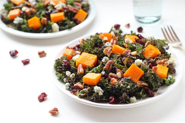 Holiday Kale Salad- tossed in an apple cider mustard vinaigrette and topped with roasted butternut squash, cranberries, and candied maple pecans! 