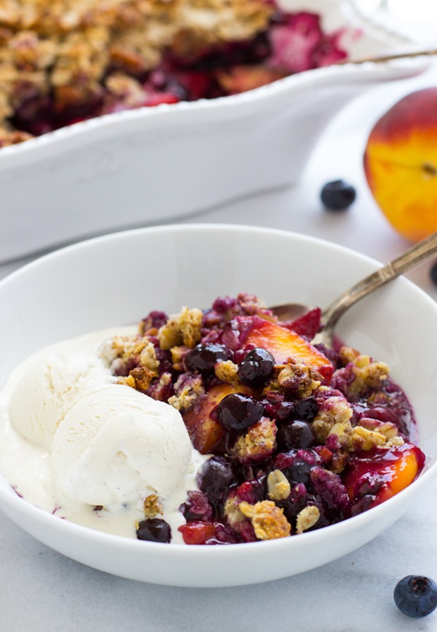 Blueberry Peach Oatmeal Crisp- made with whole grain oats and fresh fruit, this crisp is lightly sweetened and utterly delicious. Paired with vanilla ice cream, it makes for the perfect summer treat!