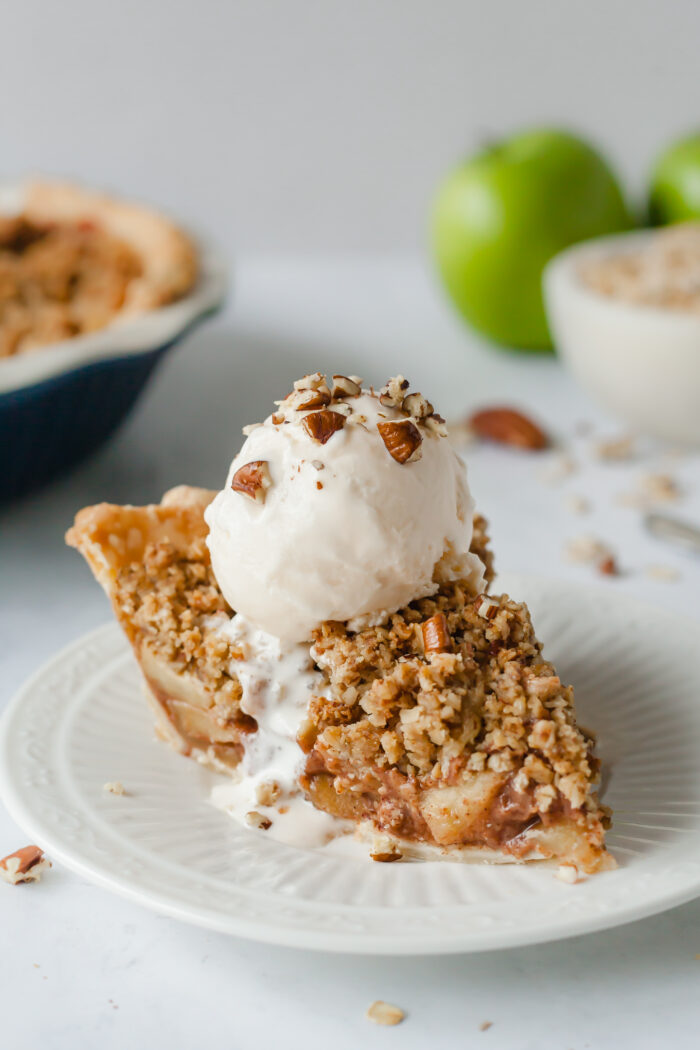 Vegan Apple Crumb Pie- Made with an oatmeal-pecan crumb topping that tastes like fresh baked granola, this vegan apple pie is a crowd pleaser! (easily made gluten-free)