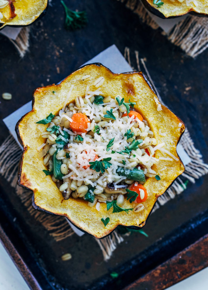 Barley Stuffed Acorn Squash- roasted acorn squash stuffed with creamy barley and seasonal vegetables. Super satisfying and perfect for a plant-based main course!