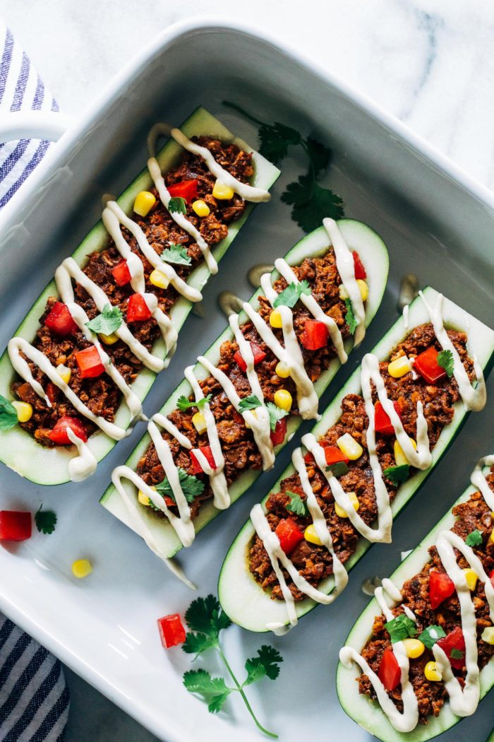 Vegan Zucchini Taco Boats- chopped walnuts and mushrooms give these plant-based taco boats a hearty texture packed full of protein and healthy fats. Drizzled with a cheesy cashew cream for ultimate bliss. (vegan, grain-free and gluten-free)