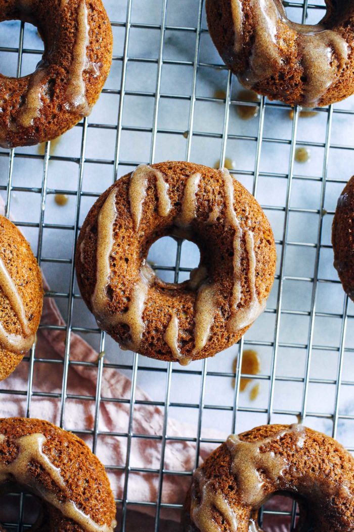 Vegan Apple Cider Donuts with Caramel Glaze- a simple mix of almond and oat flour gives these baked donuts a delicious cake-like texture. Topped with a refined sugar-free caramel glaze, they're irresistible! (vegan + gluten-free) 