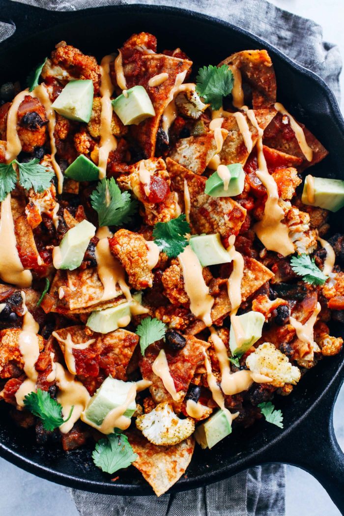 Roasted Cauliflower Chilaquiles- crispy baked tortillas are layered with roasted cauliflower, enchilada sauce, and black beans then drizzled with nacho cashew cheeze sauce. Easy to make and so delicious! (vegan + gluten-free)