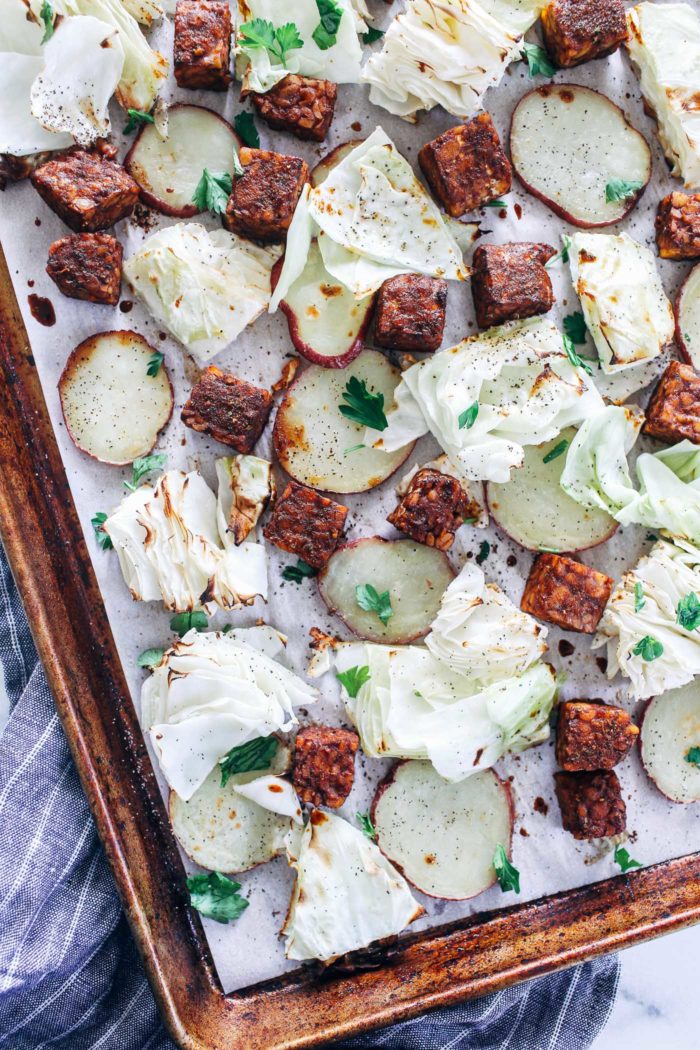 Sheet Pan Cabbage and Tempeh with Mustard Tahini Vinaigrette- cubed tempeh gets roasted in a savory marinade alongside cabbage and baby red potatoes. Served with a creamy mustard tahini vinaigrette, this one-pan meal is as easy as it is delicious! (grain-free)