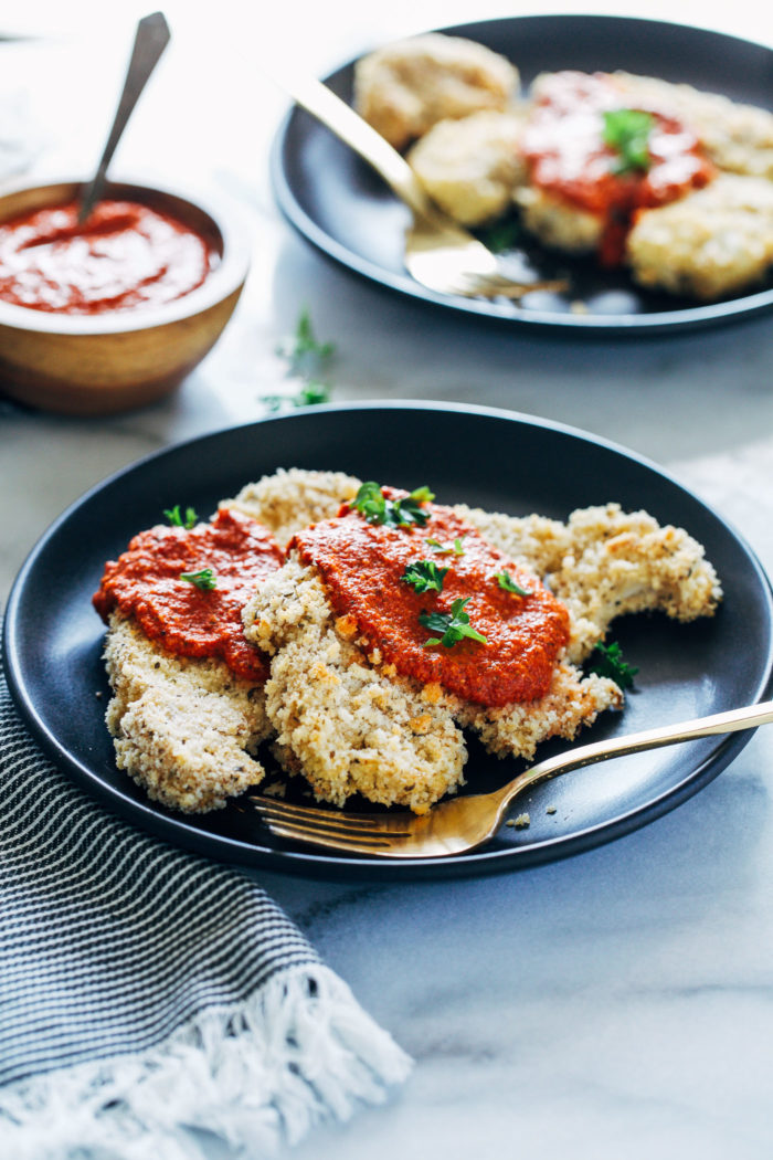 Herb Crusted Cauliflower Steaks with Romesco Sauce- thick cauliflower steaks are coated with crispy panko breadcrumbs and fresh herbs, and served with a garlicky red pepper sauce. 