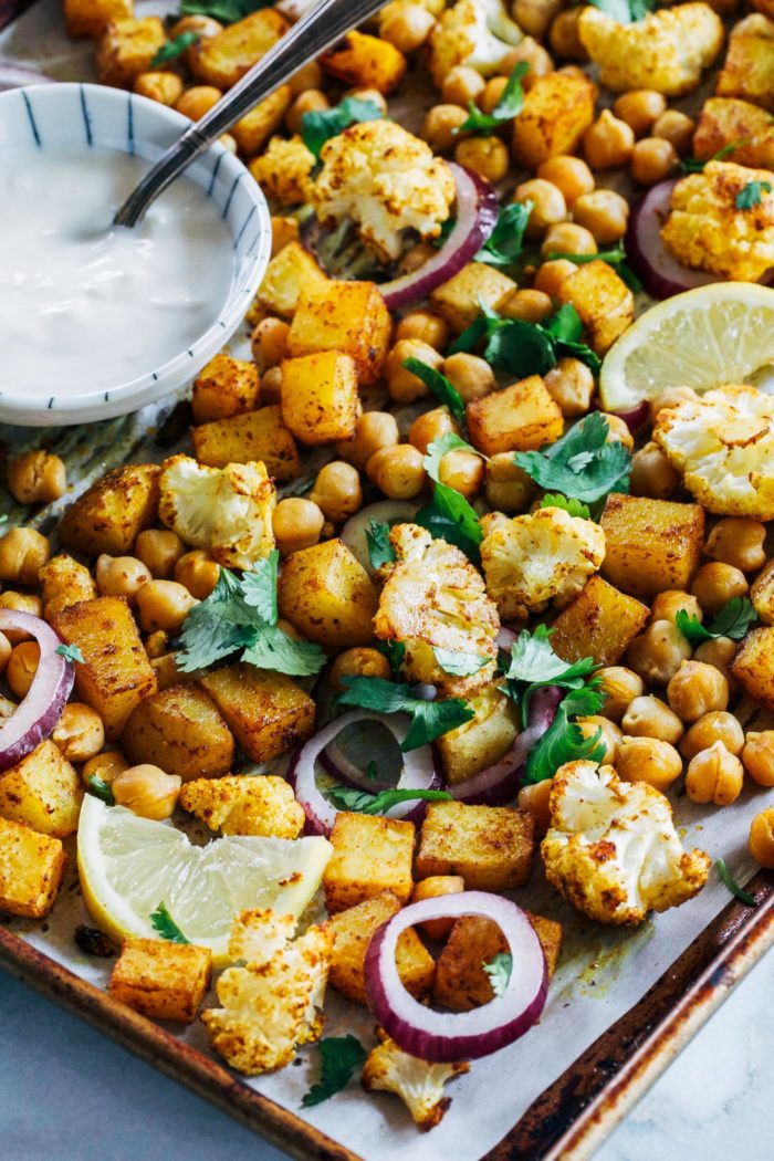 Sheet Pan Chickpea Tikka- roasted cauliflower, potatoes and chickpeas are tossed with Indian spices and served with a cooling ginger-garlic and lemon yogurt sauce. Simple to make and clean-up is a breeze! (vegan, gluten-free, grain-free)