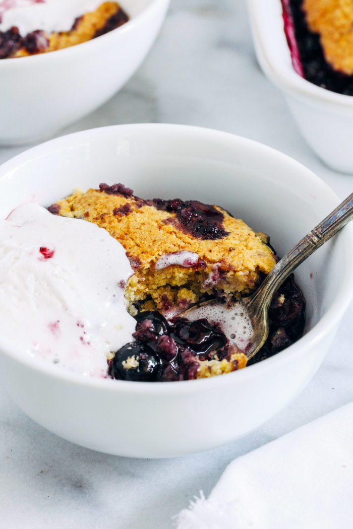 Blueberry Cornbread Cobber- naturally sweetened blueberries are topped with a whole grain cornbread crust for a deliciously wholesome summer dessert. Top with coconut whipped cream for ultimate bliss! #vegan #glutenfree #plantbased