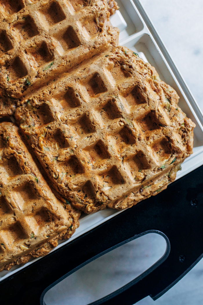 Zucchini Oat Protein Waffles- made with whole grain rolled oats, hemp seeds, almond butter and yogurt, these waffles are packed full of plant-based protein and fiber. They freeze well and are perfect to prep for busy weekday mornings! #vegan #glutenfree #healthybreakfast #waffles #plantbased #protein