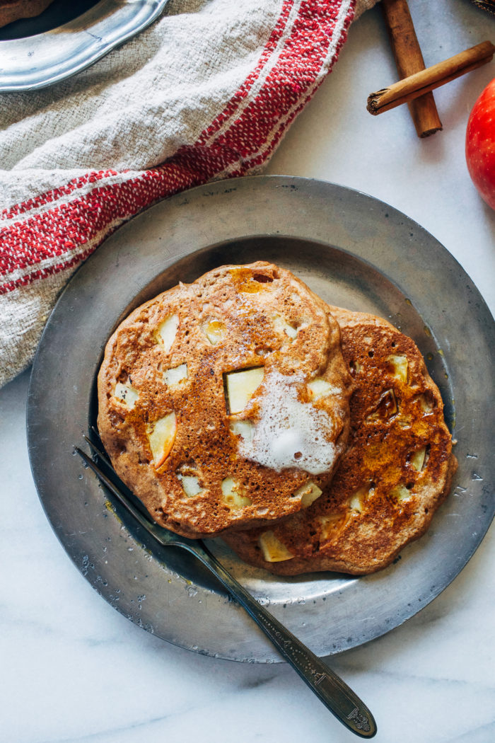 Fluffy Apple Cinnamon Pancakes- made with whole grain flour and fresh chunks of apple, these pancakes will have you jumping out of bed in the morning! #wholegrain #healthyeats #fallfood 