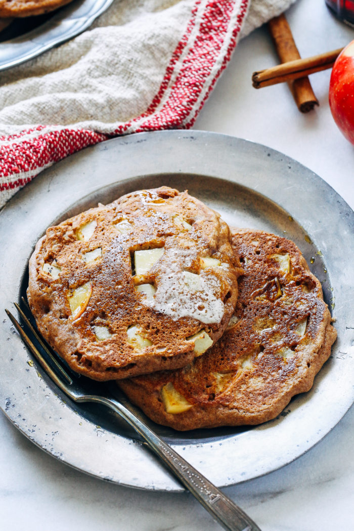 Fluffy Apple Cinnamon Pancakes- made with whole grain flour and fresh chunks of apple, these pancakes will have you jumping out of bed in the morning! #wholegrain #healthyeats #fallfood 