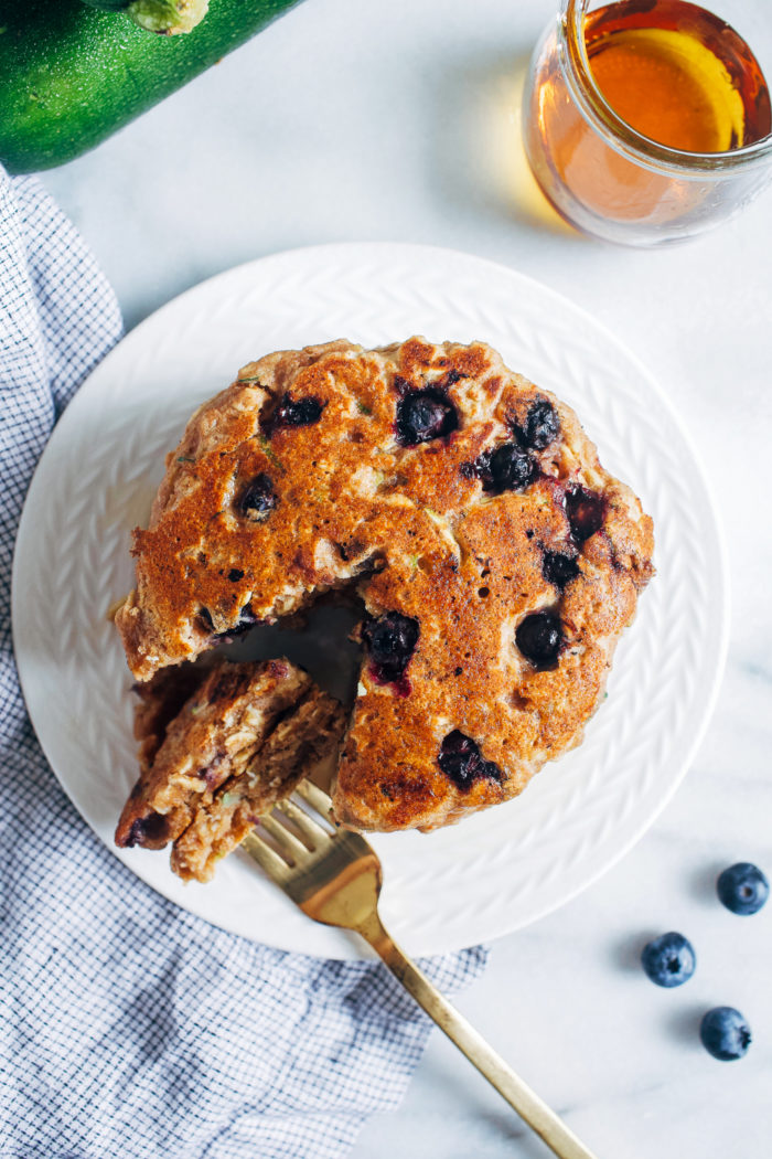 Blueberry Zucchini Oatmeal Pancakes- Made with whole grain flour and rolled oats, these vegan zucchini pancakes are hearty and will keep you full for hours!