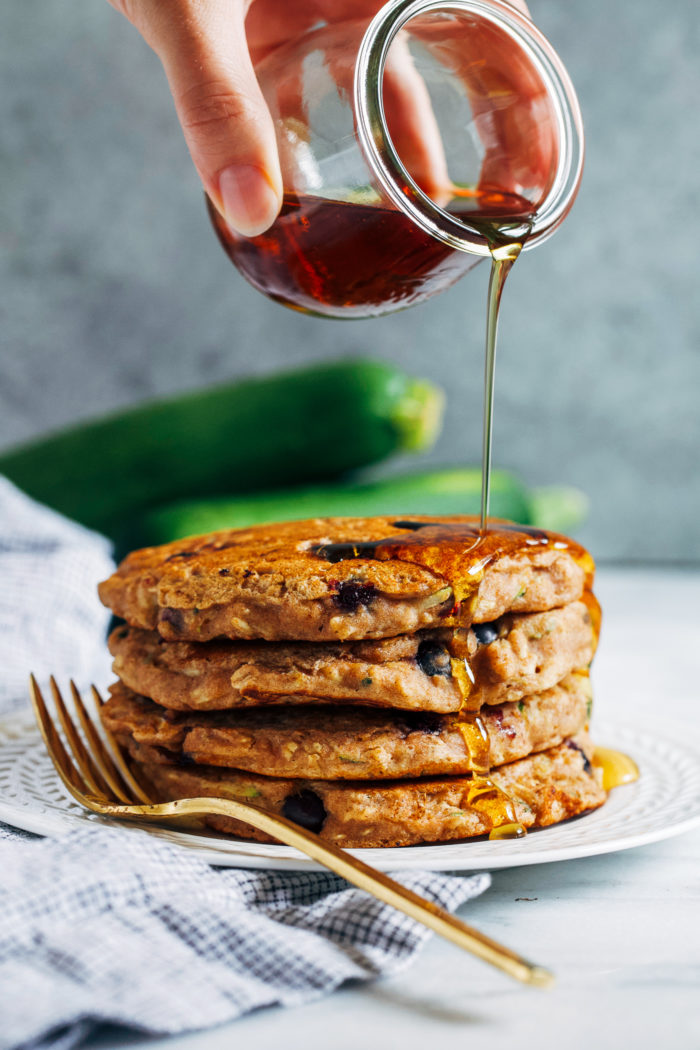 Blueberry Zucchini Oatmeal Pancakes- Made with whole grain flour and rolled oats, these vegan zucchini pancakes are hearty and will keep you full for hours!