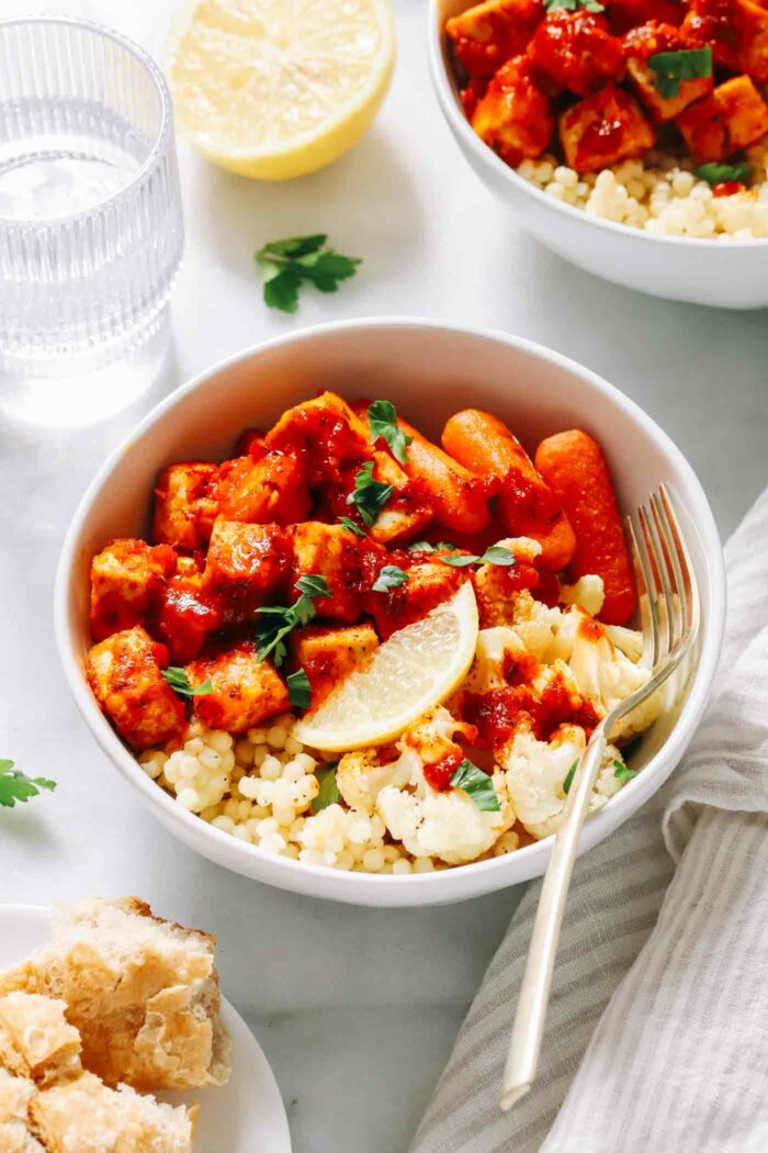 Honey Harissa Tofu Bowls- Crispy baked tofu gets coated in a flavorful honey harissa sauce and served with roasted vegetables and couscous for a protein-packed nourishing meal!  (vegan + gluten-free option)